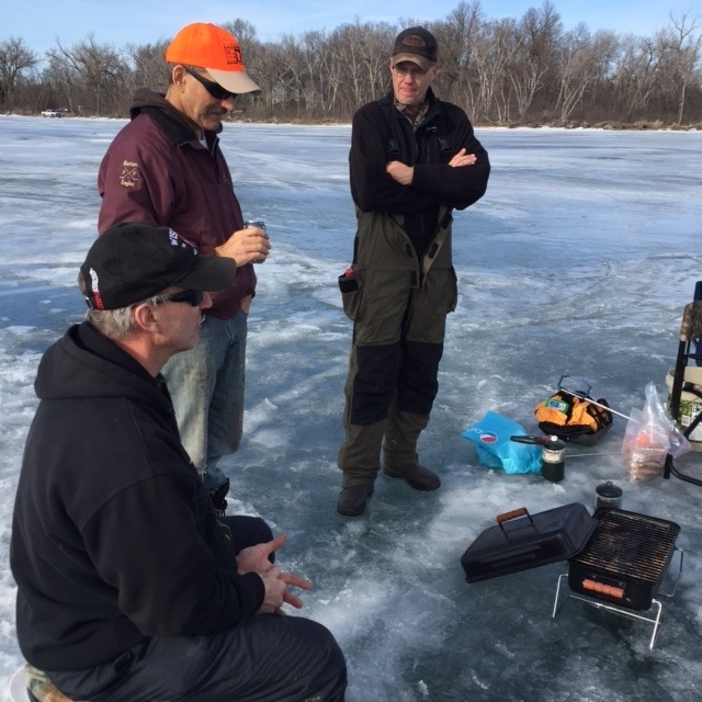 Members fishing, visiting and grilling at the FFF&GC ice fishing event.